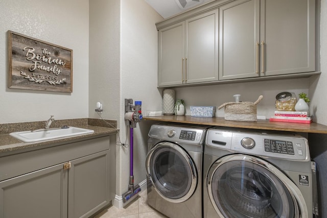 washroom featuring a sink, cabinet space, separate washer and dryer, and light tile patterned flooring