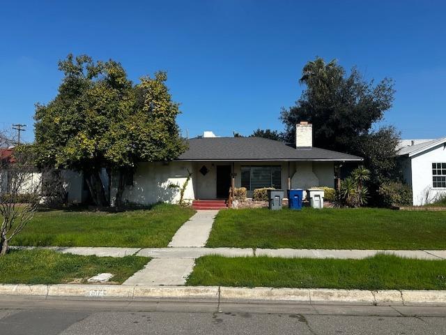 ranch-style house with stucco siding and a front yard