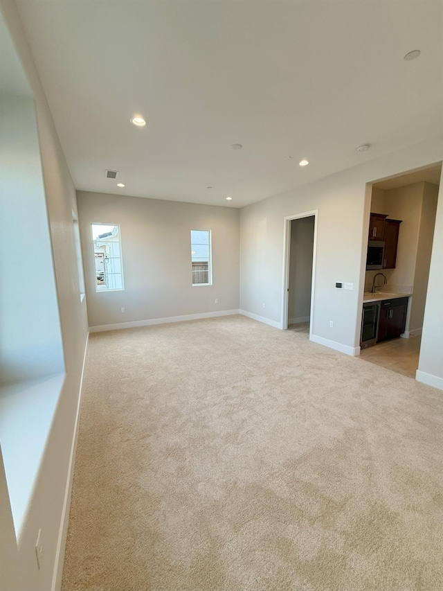 empty room featuring visible vents, recessed lighting, baseboards, and light carpet