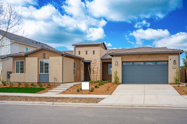 view of front of property with a garage, stone siding, driveway, and stucco siding