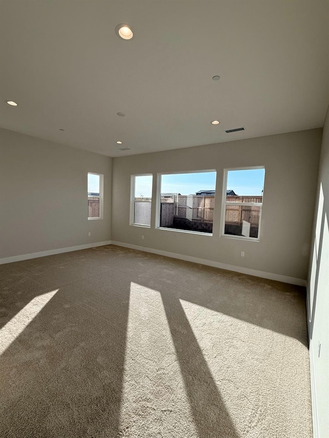 spare room with recessed lighting, visible vents, carpet floors, and baseboards