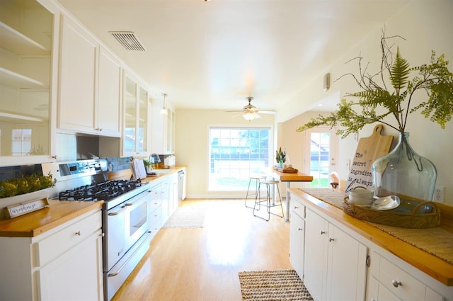 kitchen with visible vents, stainless steel range with gas stovetop, white cabinets, and light wood finished floors