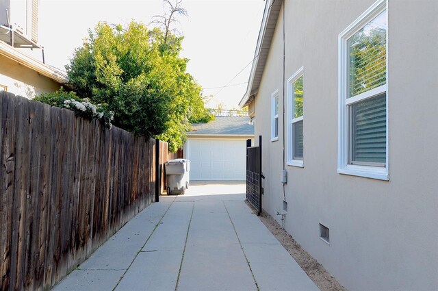 view of home's exterior featuring crawl space, stucco siding, a garage, and fence