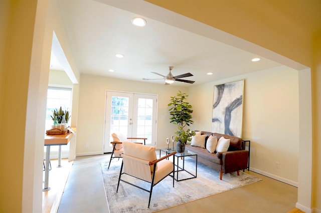 living room featuring recessed lighting, french doors, baseboards, and finished concrete floors