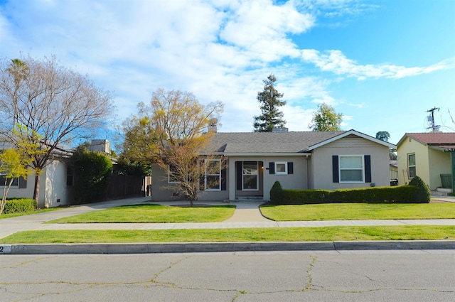 single story home with a front lawn, driveway, and stucco siding