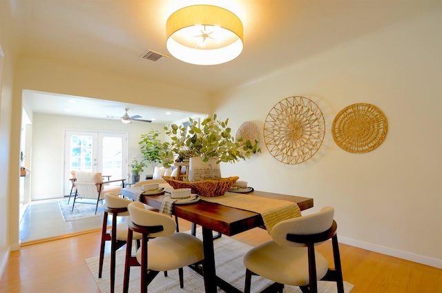 dining space featuring light wood-style floors, visible vents, french doors, and baseboards