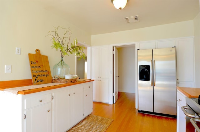 kitchen with light wood finished floors, visible vents, light countertops, stainless steel refrigerator with ice dispenser, and white cabinetry