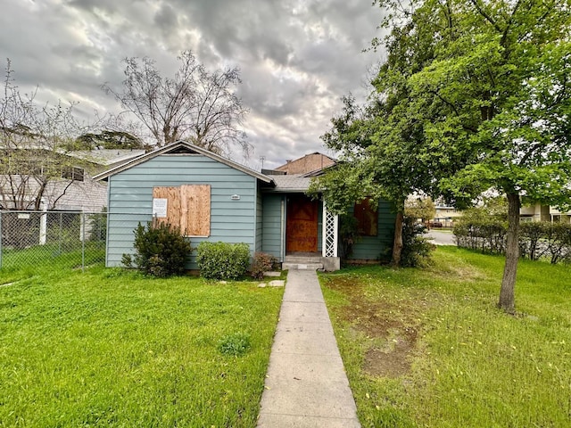 view of front of house featuring a front lawn and fence