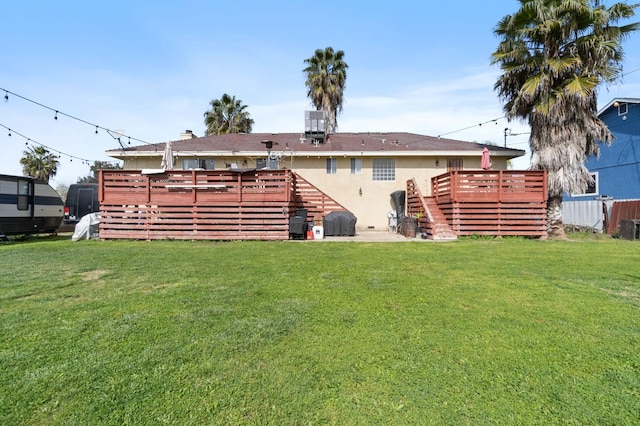 rear view of property with a deck, a yard, cooling unit, and stucco siding