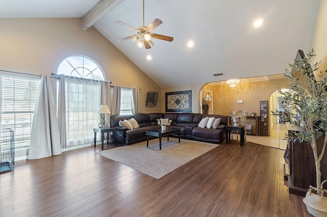 living room with beam ceiling, wood finished floors, arched walkways, and high vaulted ceiling