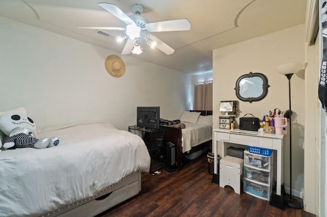 bedroom with ceiling fan, visible vents, and dark wood finished floors