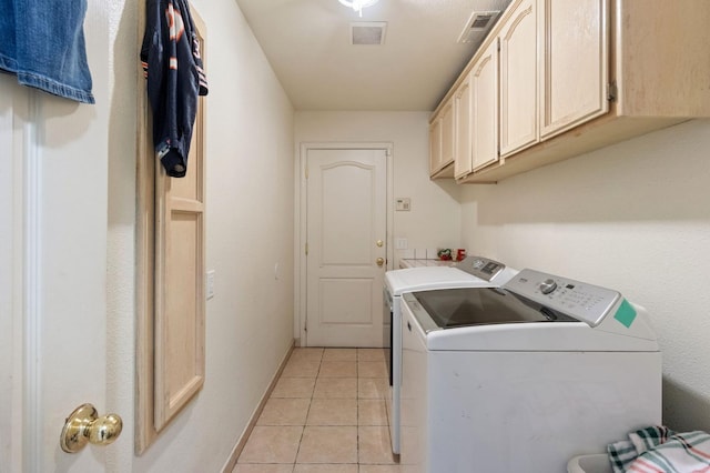 clothes washing area with light tile patterned floors, visible vents, cabinet space, and washing machine and dryer