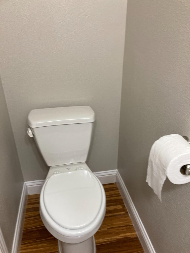 bathroom featuring baseboards, toilet, and wood finished floors