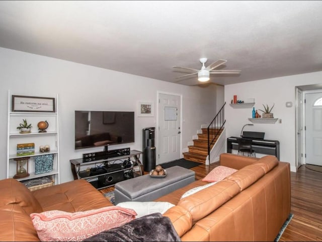 living room with stairs, wood finished floors, and a ceiling fan