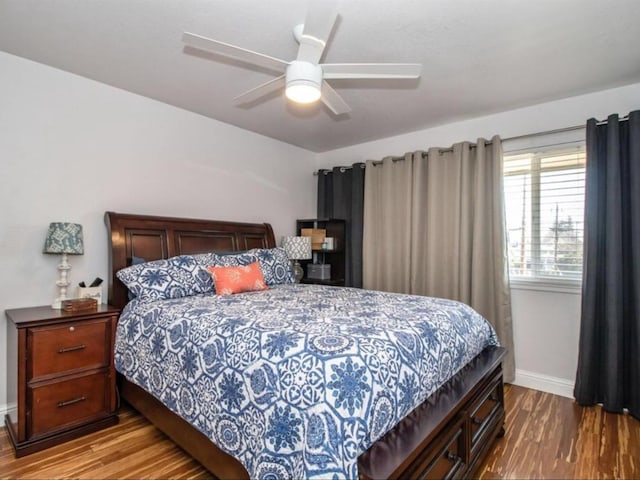 bedroom with ceiling fan, baseboards, and wood finished floors