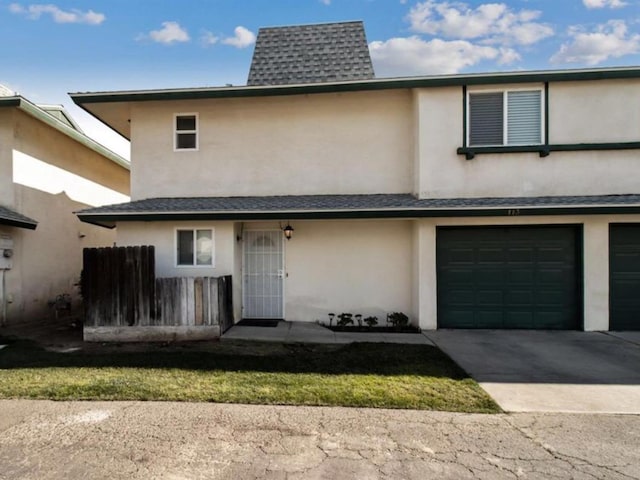 townhome / multi-family property with stucco siding, an attached garage, and driveway