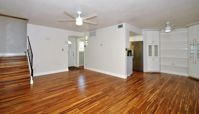 unfurnished living room with stairs, wood finished floors, visible vents, and ceiling fan