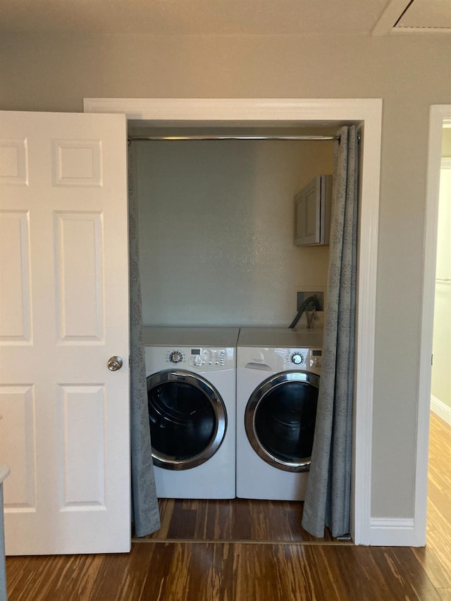 washroom with baseboards, independent washer and dryer, dark wood-style flooring, and laundry area