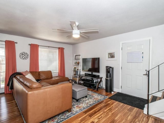 living room featuring wood finished floors, baseboards, and ceiling fan