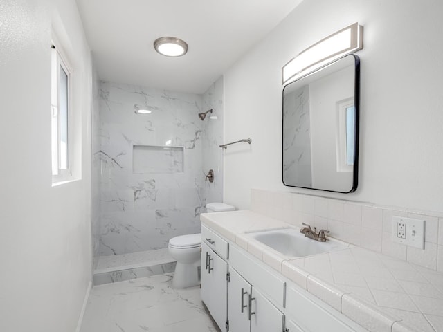 full bathroom with toilet, marble finish floor, a marble finish shower, baseboards, and vanity