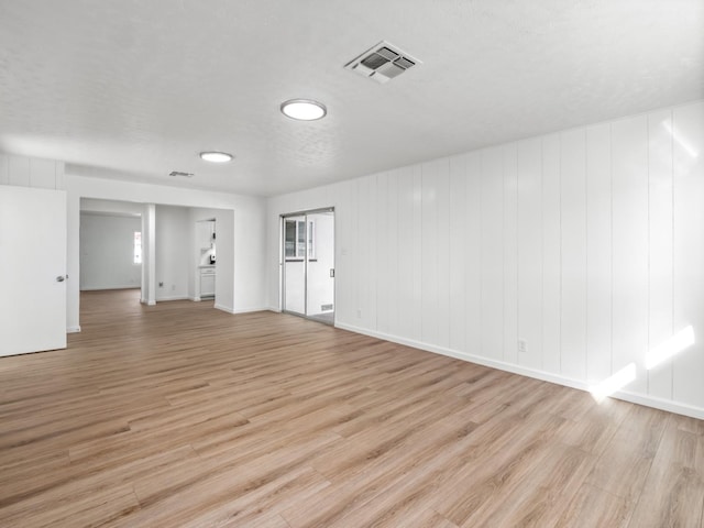 unfurnished room featuring baseboards, visible vents, and light wood-type flooring