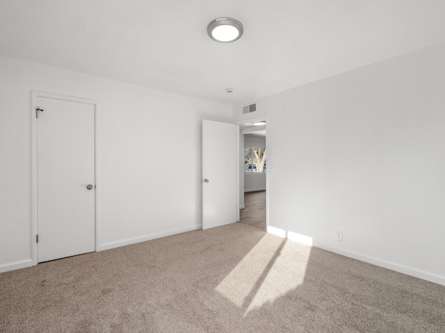 unfurnished room with visible vents, carpet floors, and baseboards