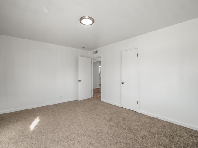 spare room with visible vents, baseboards, and carpet