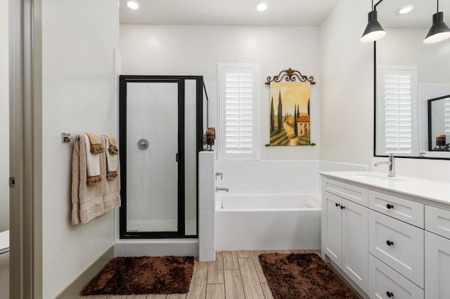 full bathroom featuring a shower stall, wood finish floors, toilet, a bath, and vanity