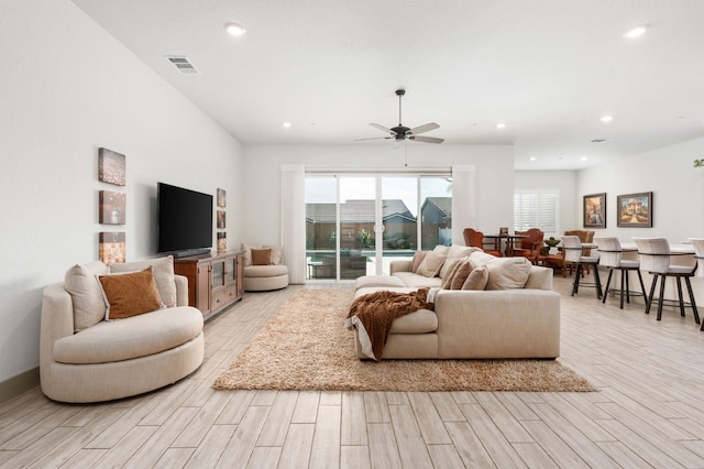 living room with light wood finished floors, visible vents, baseboards, ceiling fan, and recessed lighting