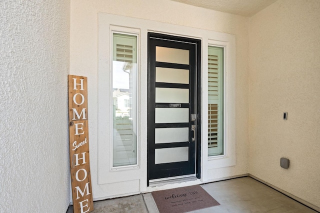 entrance to property with stucco siding