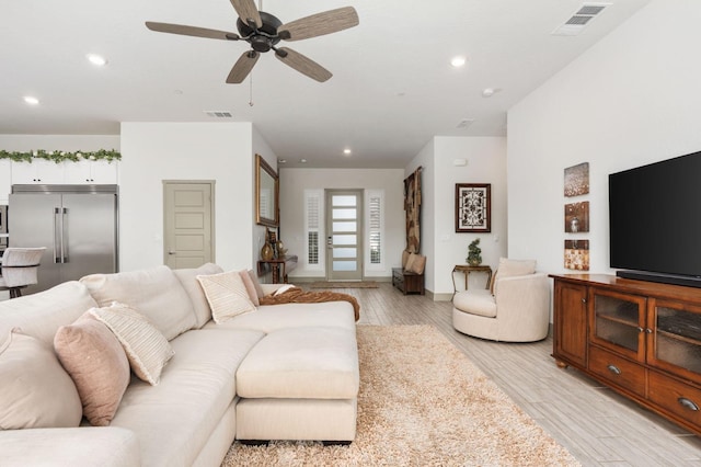 living room featuring recessed lighting, light wood-style floors, and visible vents