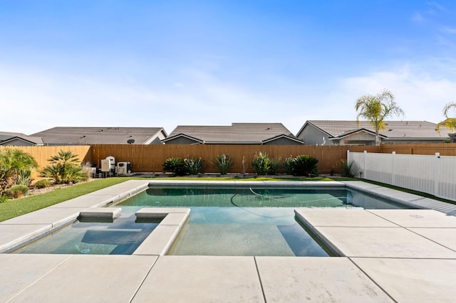 view of swimming pool featuring a patio, a pool with connected hot tub, and a fenced backyard