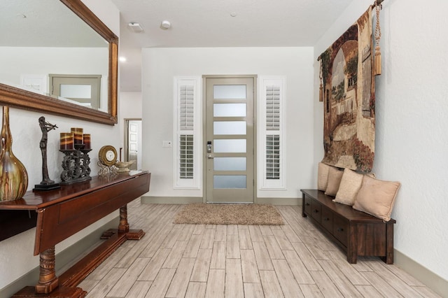 foyer with baseboards and wood tiled floor