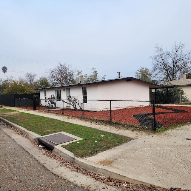 view of front of home with a fenced front yard and an attached carport