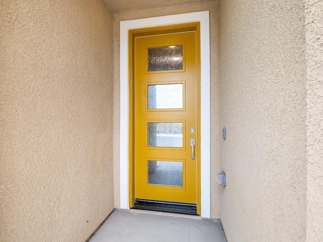 doorway to property featuring stucco siding