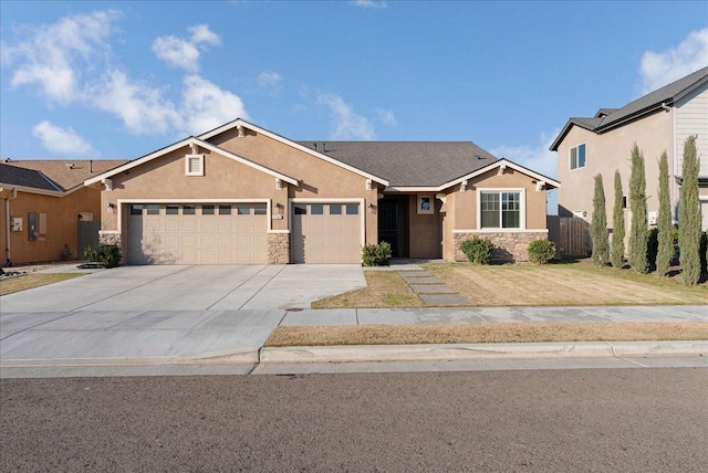 view of front of home featuring driveway, a garage, stone siding, and stucco siding