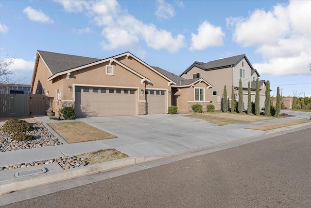 view of front of property featuring fence, concrete driveway, stucco siding, a garage, and a gate