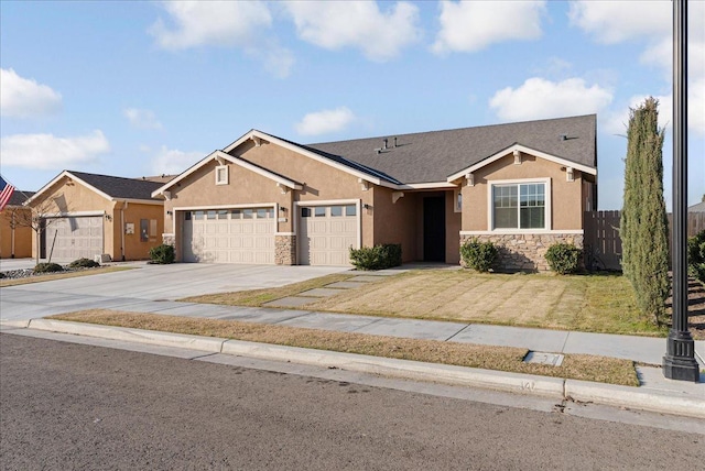 view of front of property with stucco siding, driveway, stone siding, fence, and a garage