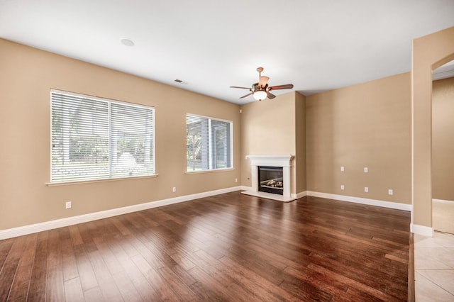 2565 Powers Ave, Clovis, CA 93619 - unfurnished living room with wood finished floors, ceiling fan, baseboards, and a glass covered fireplace