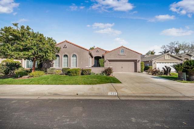 mediterranean / spanish-style house featuring stucco siding, driveway, a tile roof, an attached garage, and a front yard