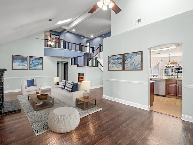 living area featuring ceiling fan, wood finished floors, and stairs