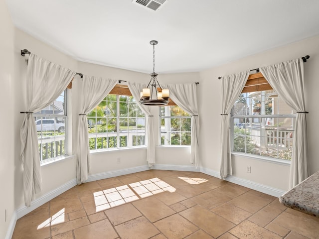 unfurnished dining area featuring stone tile floors, visible vents, a healthy amount of sunlight, and baseboards