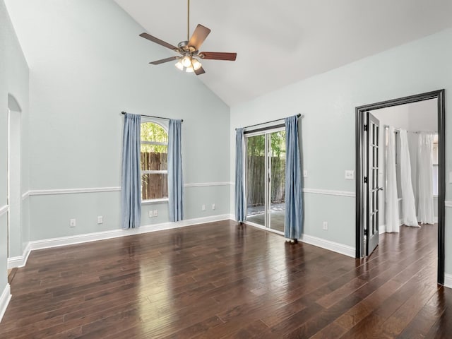 empty room with wood finished floors, baseboards, high vaulted ceiling, arched walkways, and ceiling fan