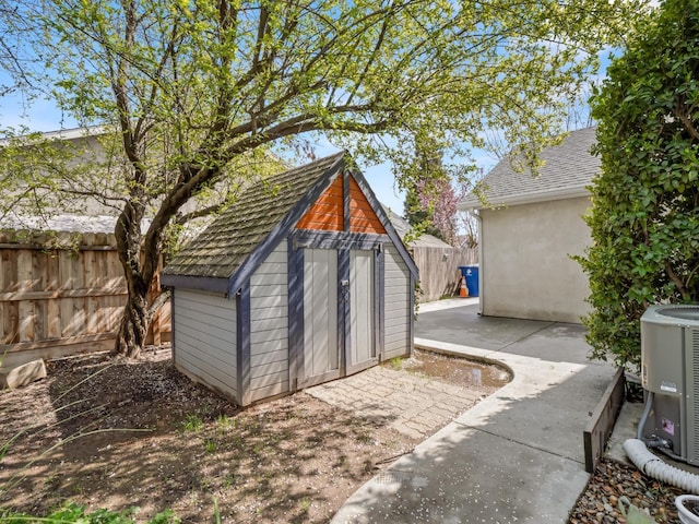 view of shed with central air condition unit and a fenced backyard