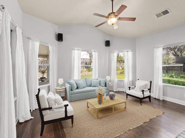 living area with baseboards, visible vents, lofted ceiling, ceiling fan, and dark wood-type flooring