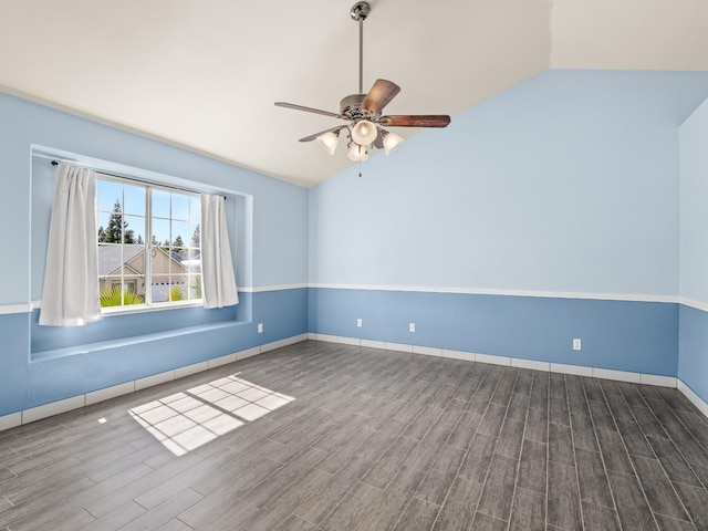 empty room with vaulted ceiling, wood finished floors, baseboards, and ceiling fan