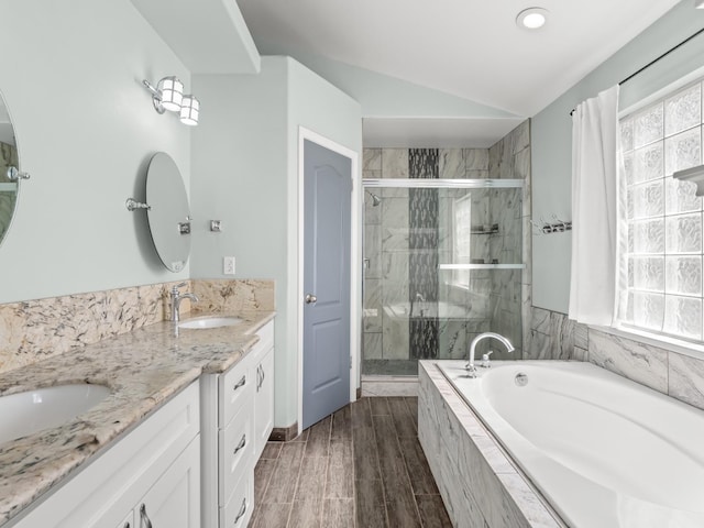 bathroom featuring lofted ceiling, double vanity, a stall shower, a sink, and a bath