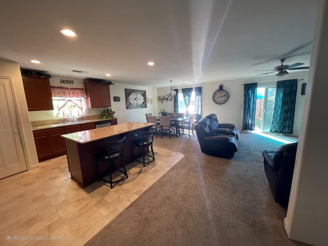 kitchen with a kitchen bar, a kitchen island, open floor plan, light countertops, and a healthy amount of sunlight