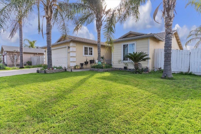 view of front of house with an attached garage, a front lawn, and fence