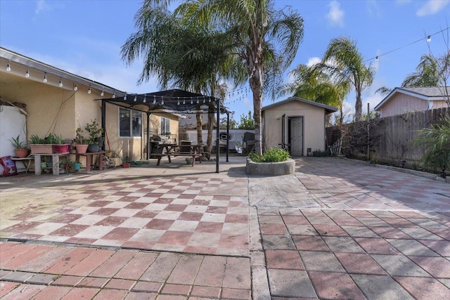 view of patio / terrace with an outdoor structure, a storage unit, fence, and a pergola